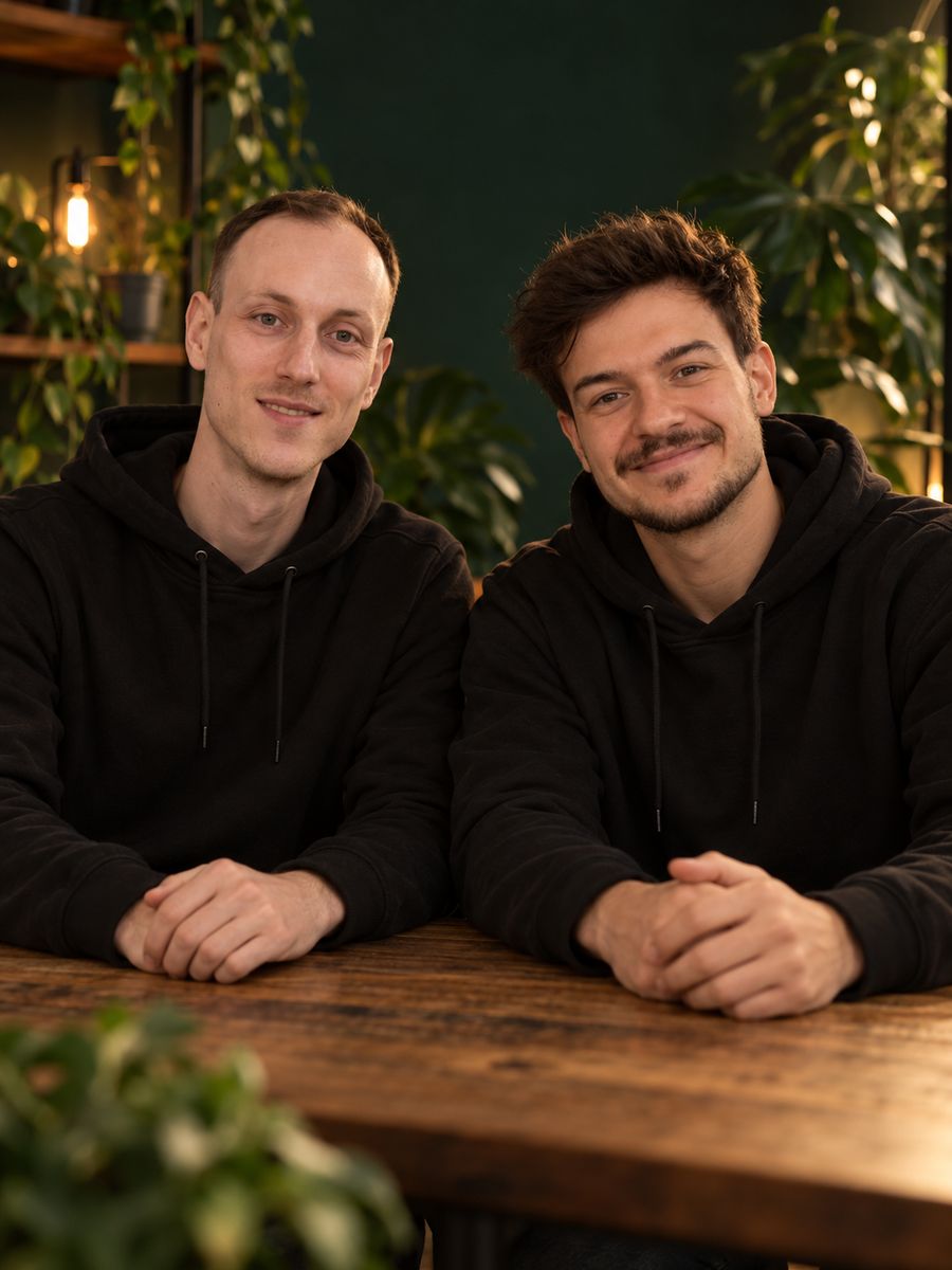 Max (links) und Tim-Maurice (rechts), die Gründer von Innen Kultur, am Holztisch